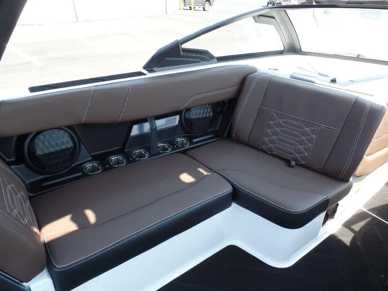 Slide: The Image of 2024 Malibu 26 LSV interior seating with brown upholstery and speaker system. - 8