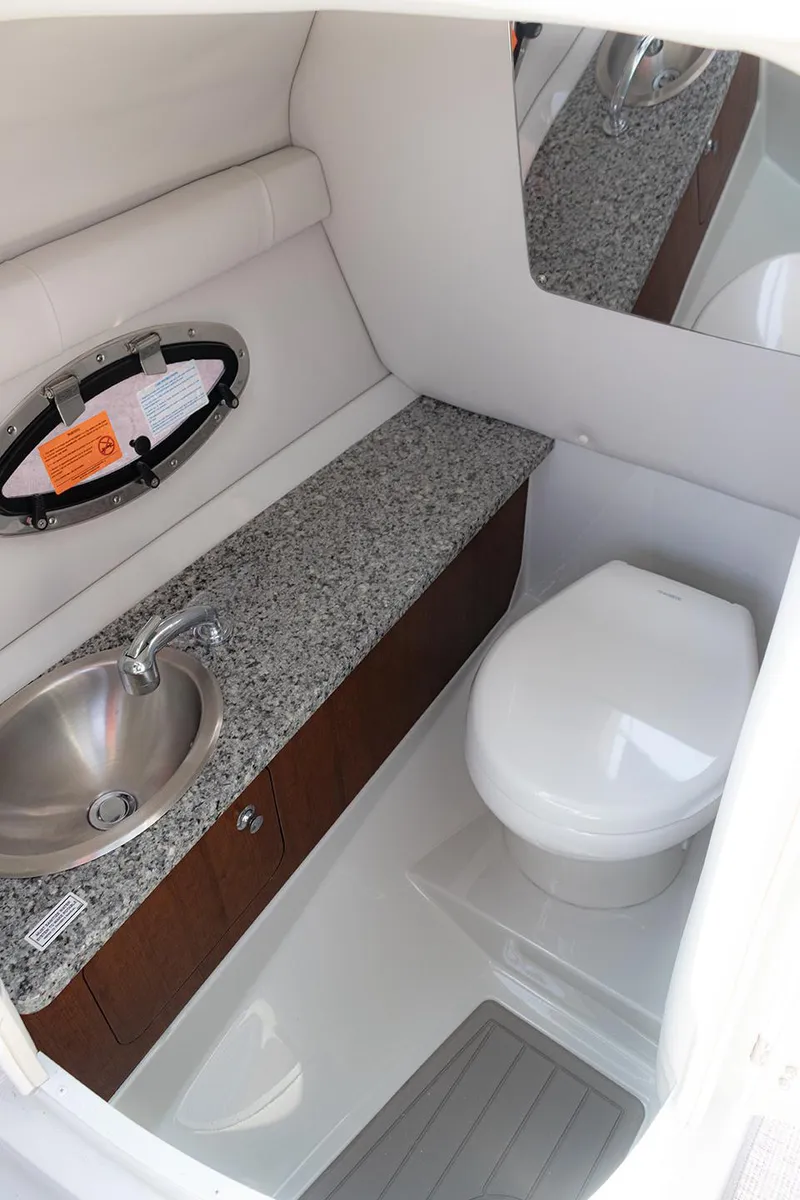 Slide: The Image of 2022 Crownline E 255 XS boat bathroom with sink, toilet, and granite countertop. - 19