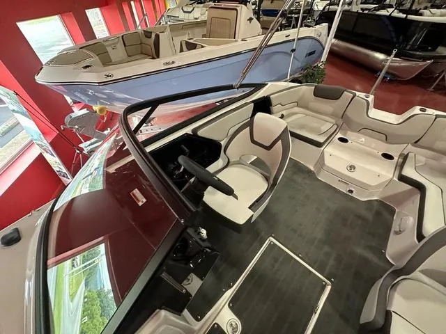 Slide: The Image of 2024 Yamaha Boats SX190 interior view in showroom, featuring modern seating and steering console. - 9