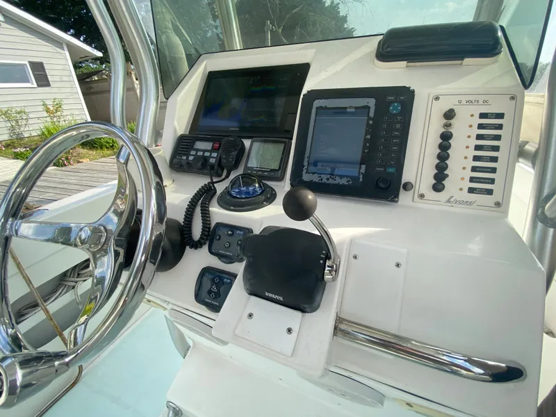 Slide: The Image of Control panel of a 2006 Kryptonite 41 CC boat with steering wheel and navigation equipment. - 16