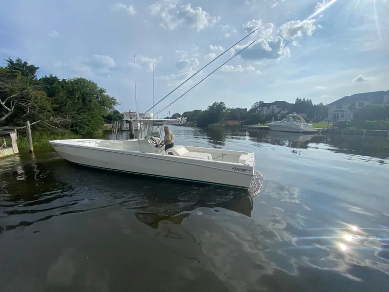 Slide: The Image of White 2006 Kryptonite 41 CC boat cruising on a calm river near residential area. - 4