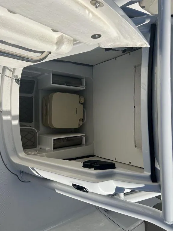 Slide: The Image of 2024 Finseeker 210 FS boat interior cabin with storage compartments and a portable toilet. - 10