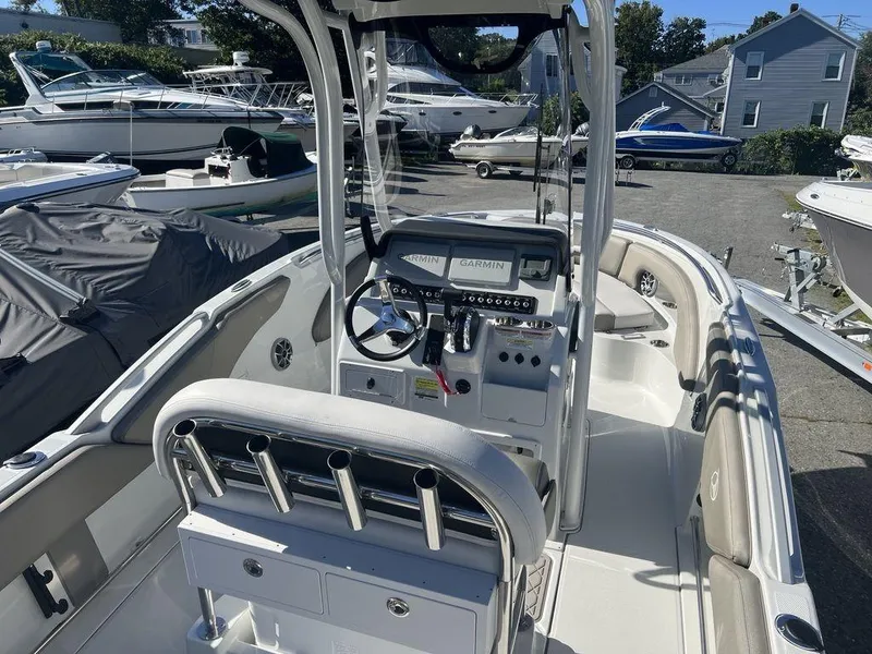 Slide: The Image of 2024 Finseeker 210 FS boat interior with console and seating, docked among other boats. - 3