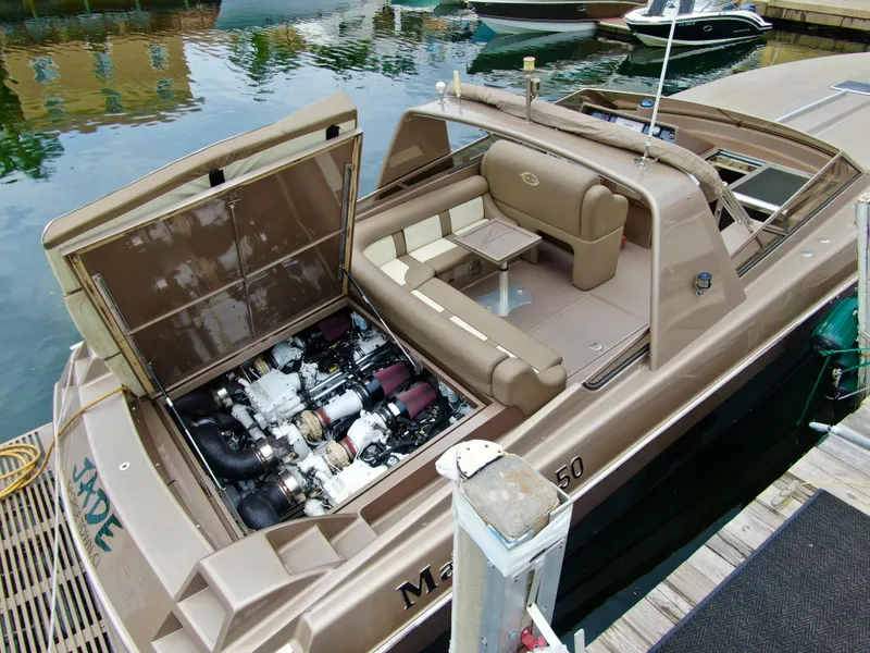 Slide: The Image of 1998 Magnum 50 Bestia boat with open engine compartment, docked at marina. - 11