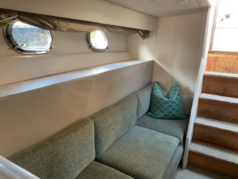 Slide: The Image of Interior of 1998 Magnum 50 Bestia yacht with cozy seating and porthole windows. - 16