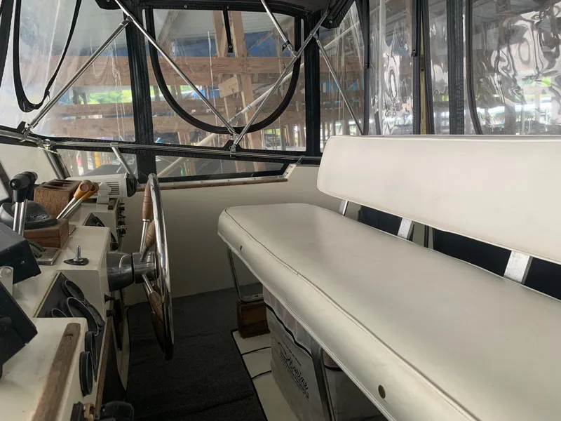 Slide: The Image of 1987 Marinette Fisherman boat interior with steering wheel and white bench seat. - 11