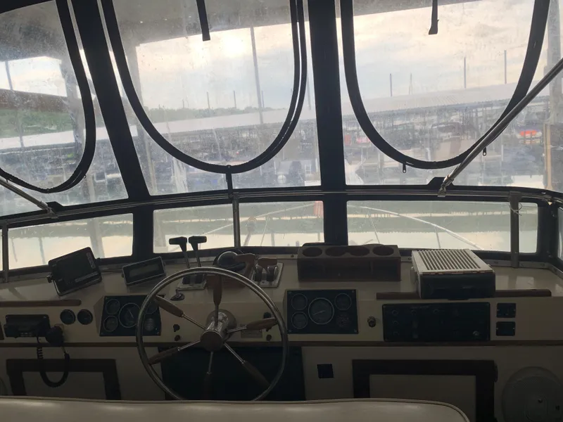 Slide: The Image of 1987 Marinette Fisherman boat cockpit with steering wheel and navigation instruments. - 13
