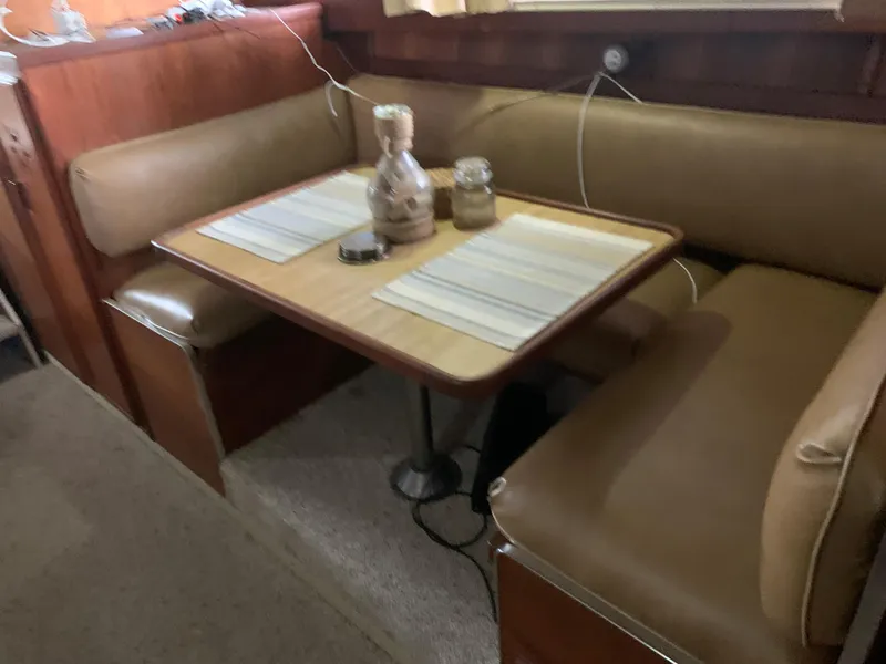 Slide: The Image of 1987 Marinette Fisherman boat interior with dining table and leather seating. - 19