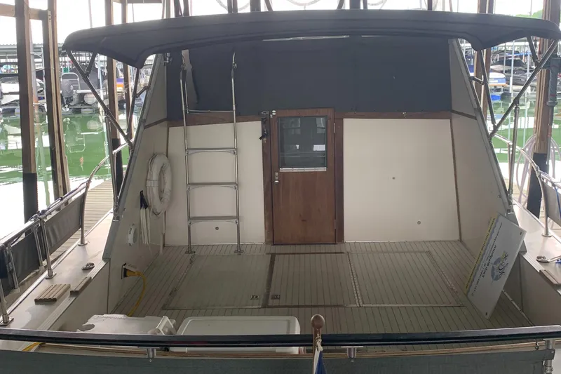 Slide: The Image of 1987 Marinette Fisherman boat with covered deck and wooden door in marina. - 2