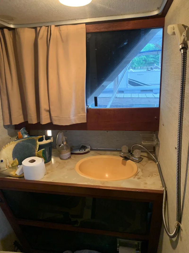 Slide: The Image of 1987 Marinette Fisherman boat bathroom with sink, window, and showerhead. - 21