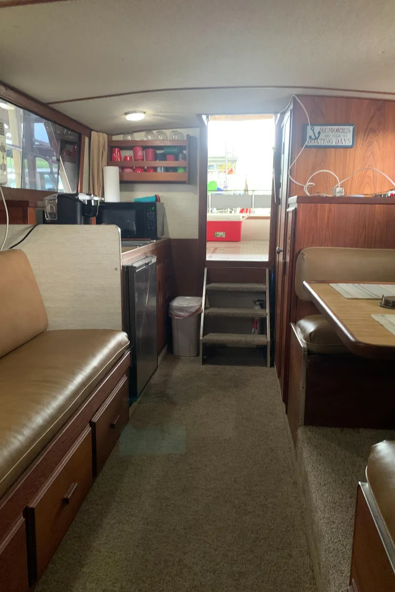 Slide: The Image of 1987 Marinette Fisherman boat interior with seating, kitchenette, and stairs. - 24