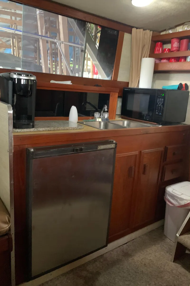 Slide: The Image of 1987 Marinette Fisherman boat kitchen with microwave, fridge, and coffee maker. - 27