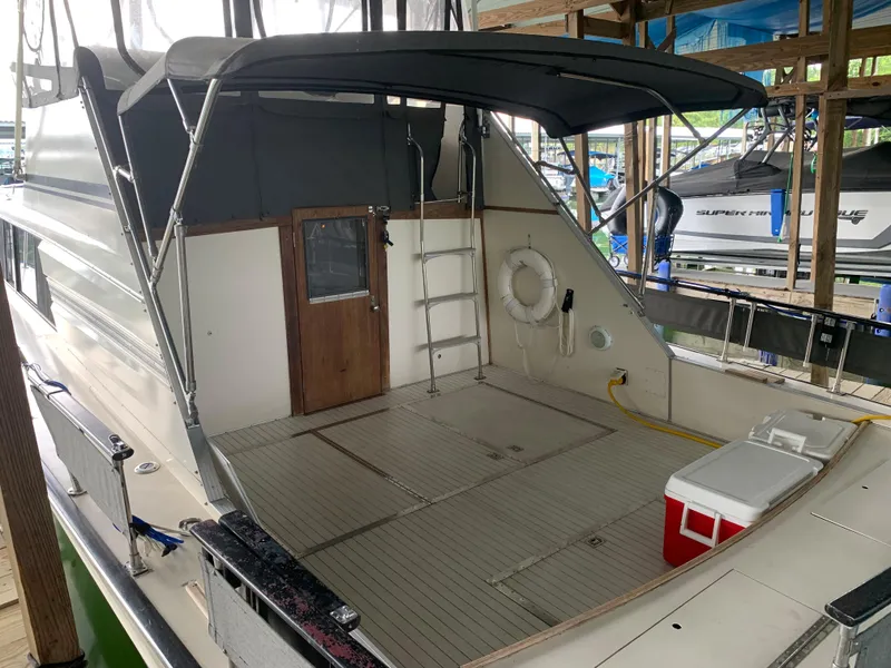 Slide: The Image of 1987 Marinette Fisherman boat with spacious deck and canopy in marina. - 6