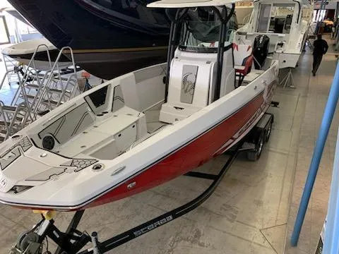 Slide: The Image of 2019 Scarab 255 Open ID boat in showroom, red and white exterior. - 38