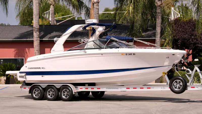 The Image of 2021 Chaparral 30 Surf boat on a trailer in a driveway. - 0