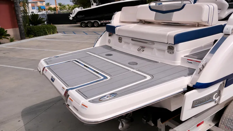 Slide: The Image of 2021 Chaparral 30 Surf boat rear deck and seating area in a parking lot. - 6