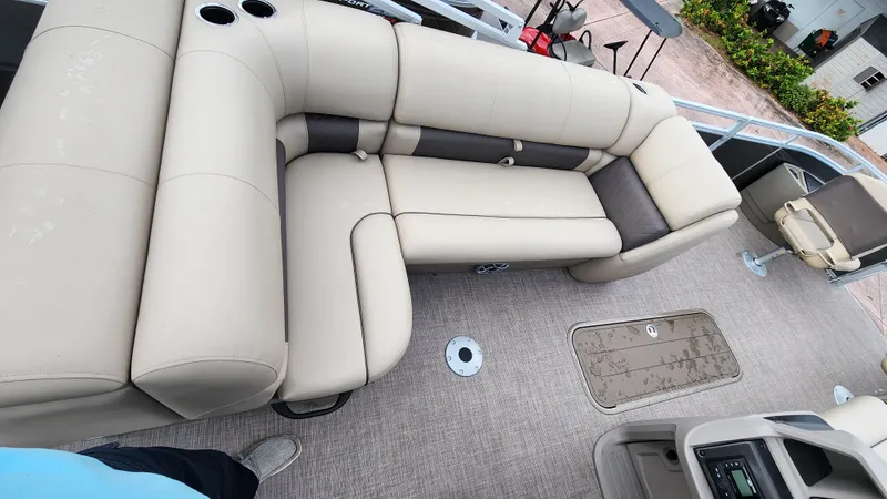 Slide: The Image of 2024 Sun Tracker Fishin' Barge 22 XP3 interior with beige seating and carpeted flooring. - 14