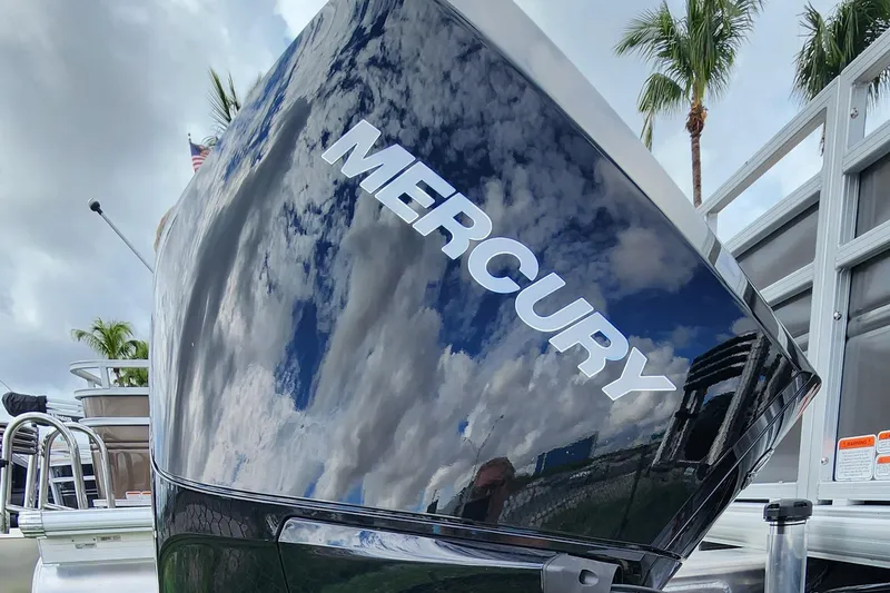 Slide: The Image of Close-up of Mercury engine on 2024 Sun Tracker Fishin' Barge 22 XP3, reflecting sky and palm trees. - 17