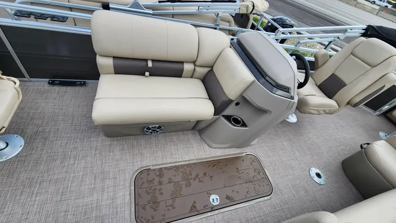 Slide: The Image of 2024 Sun Tracker Fishin' Barge 22 XP3 interior with beige seating and steering console. - 31