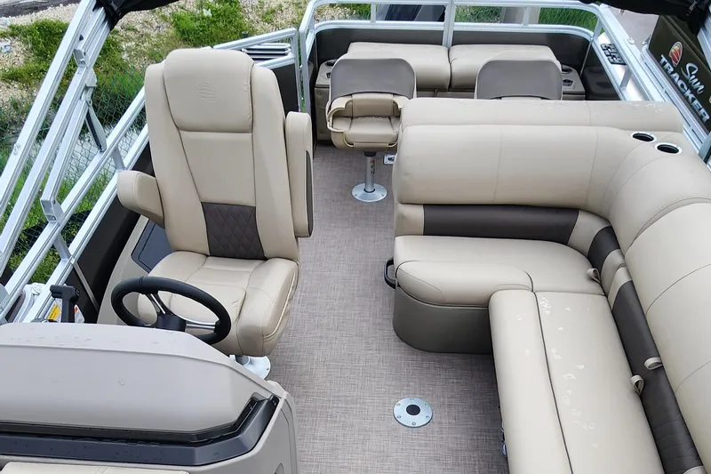 Slide: The Image of 2024 Sun Tracker Fishin' Barge 22 XP3 interior with beige seating and steering wheel. - 7
