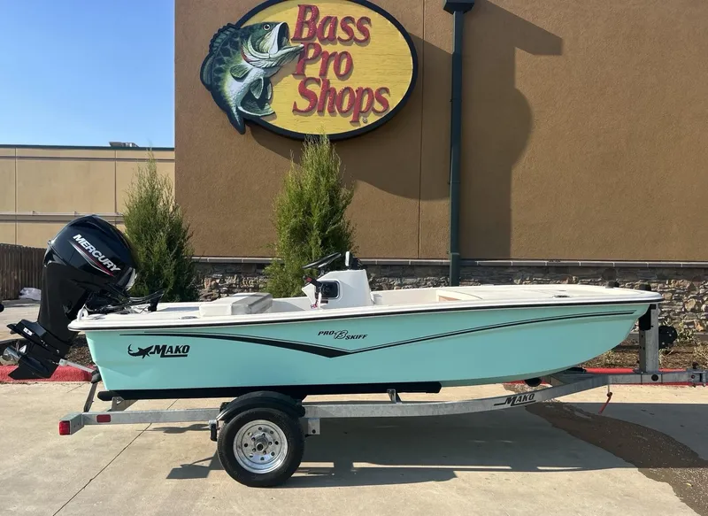 Slide: The Image of 2024 Mako Pro Skiff 13 CC boat displayed outside Bass Pro Shops. - 0