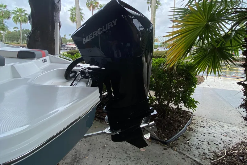 Slide: The Image of 2024 Tahoe T21 boat with Mercury outboard motor, docked near tropical plants. - 5