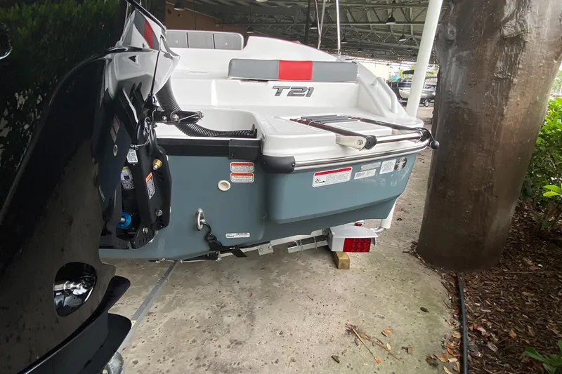 Slide: The Image of 2024 Tahoe T21 boat rear view in a covered dock area. - 7