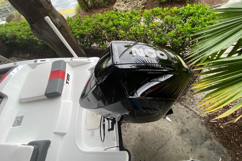 Slide: The Image of 2024 Tahoe T21 boat with Mercury 400 outboard motor, docked near lush greenery. - 8