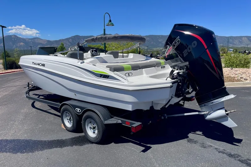 Slide: The Image of 2024 Tahoe T21 boat on trailer with powerful outboard motor, set against scenic mountain backdrop. - 1