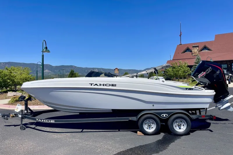Slide: The Image of 2024 Tahoe T21 boat on trailer, parked outdoors with scenic mountain backdrop. - 3