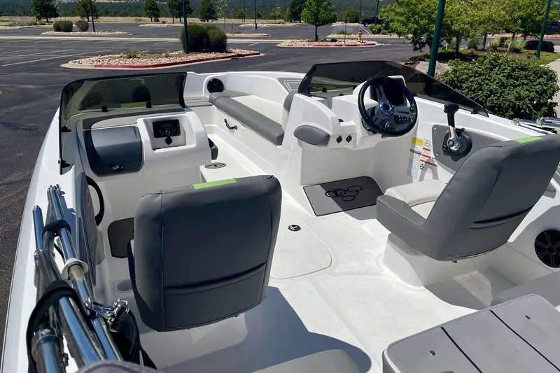 Slide: The Image of 2024 Tahoe T21 boat interior with modern seating and steering wheel in a sunny outdoor setting. - 2