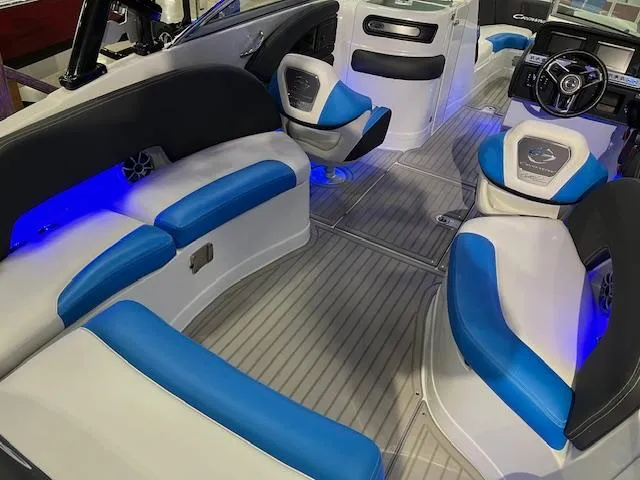 Slide: The Image of 2024 Crownline 280 SS boat interior with blue and white seating, modern dashboard, and ambient lighting. - 2