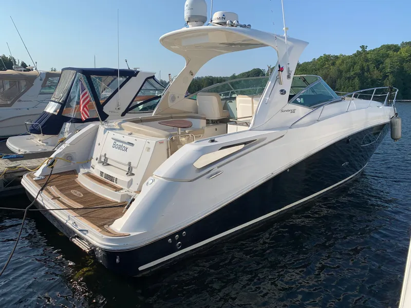 Slide: The Image of 2012 Sea Ray Sundancer 370 yacht docked, sleek design. - 14