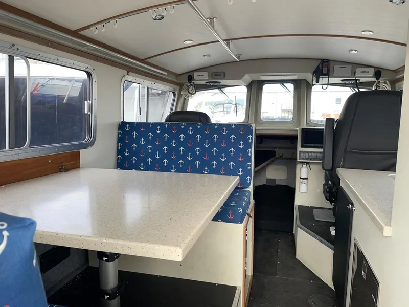 Slide: The Image of Interior of 2010 Glacier Craft Custom Aluminum boat with dining area and navigation station. - 28