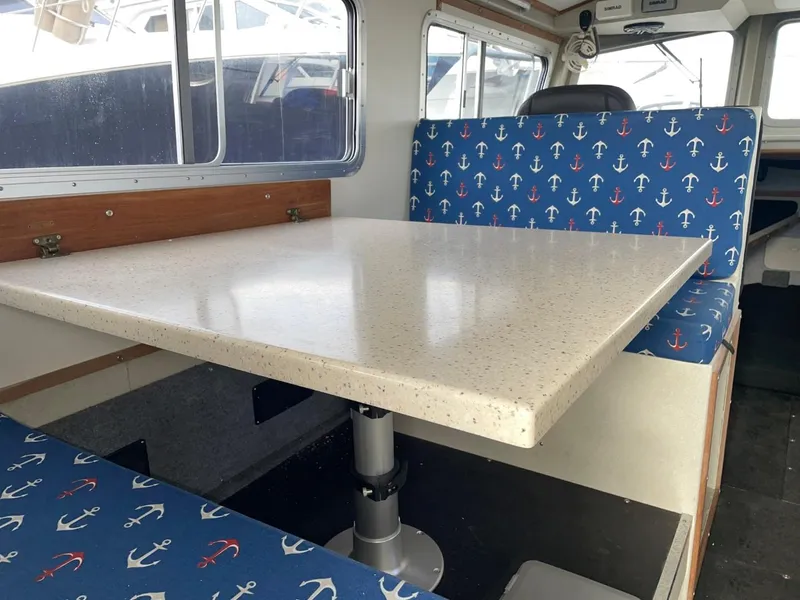 Slide: The Image of 2010 Glacier Craft Custom Aluminum boat interior with anchor-patterned seating and a dining table. - 29