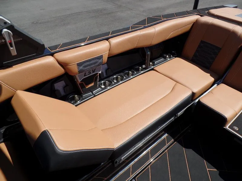 Slide: The Image of 2023 Malibu 26 LSV boat interior with tan leather seating and cup holders. - 7
