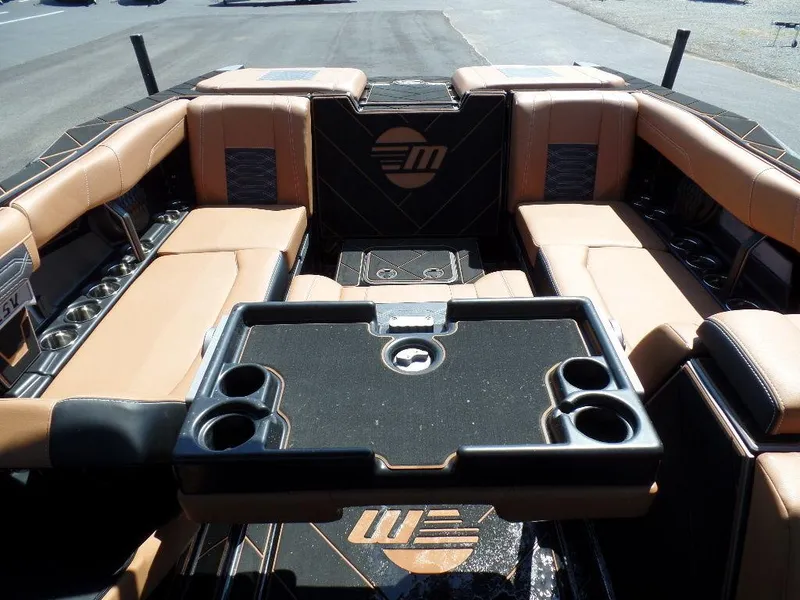 Slide: The Image of 2023 Malibu 26 LSV boat interior with tan seating and cup holders. - 8