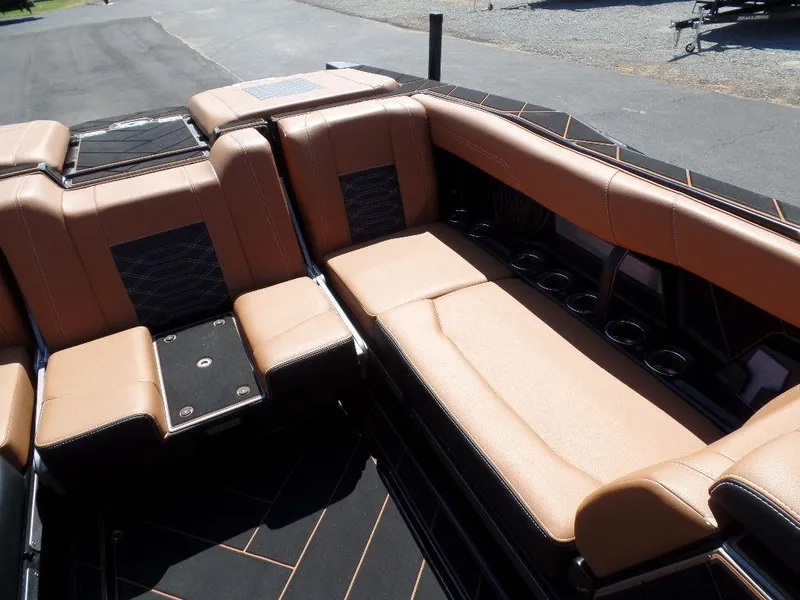 Slide: The Image of 2023 Malibu 26 LSV boat interior with tan leather seating and cup holders. - 9