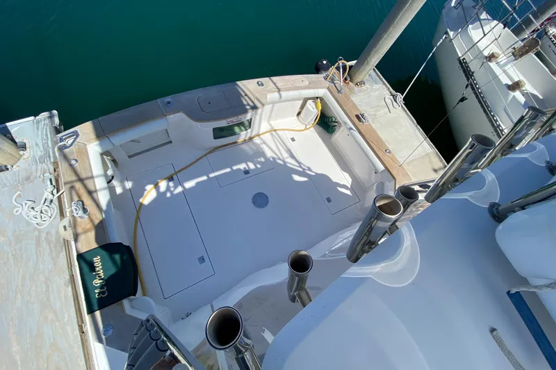 Slide: The Image of 2005 Cabo 40 Hardtop Express boat deck with fishing rod holders and dock view. - 15