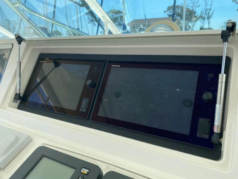 Slide: The Image of Control panel of a 2005 Cabo 40 Hardtop Express boat with navigation screens. - 19
