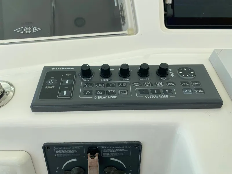 Slide: The Image of Control panel of a 2005 Cabo 40 Hardtop Express boat with various knobs and buttons. - 21