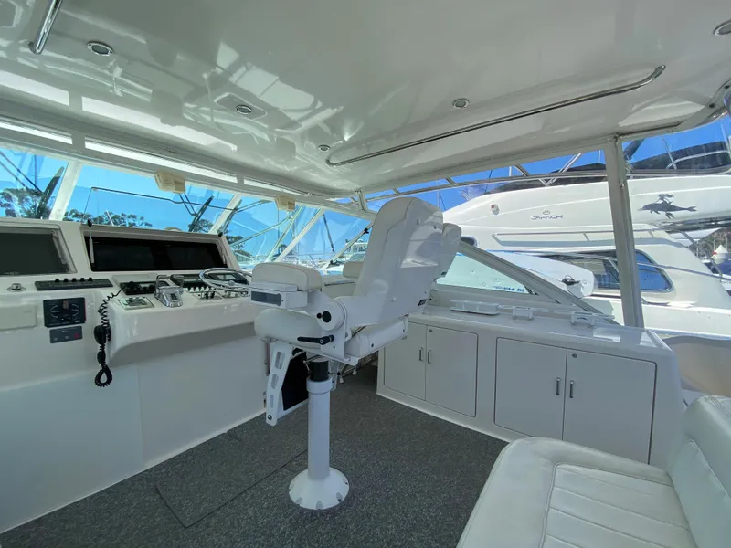 Slide: The Image of 2005 Cabo 40 Hardtop Express boat interior with helm, seating, and navigation equipment. - 24
