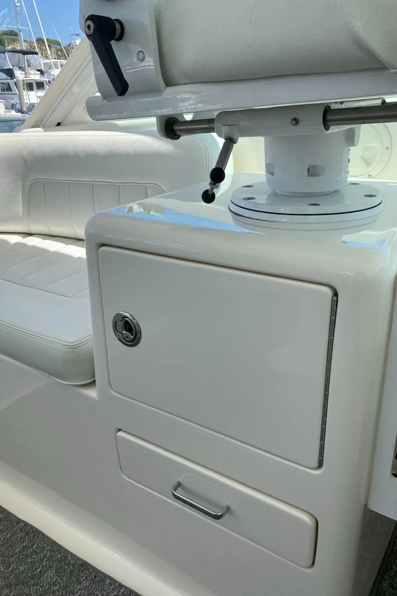 Slide: The Image of 2005 Cabo 40 Hardtop Express boat interior with white seating and storage compartments. - 30