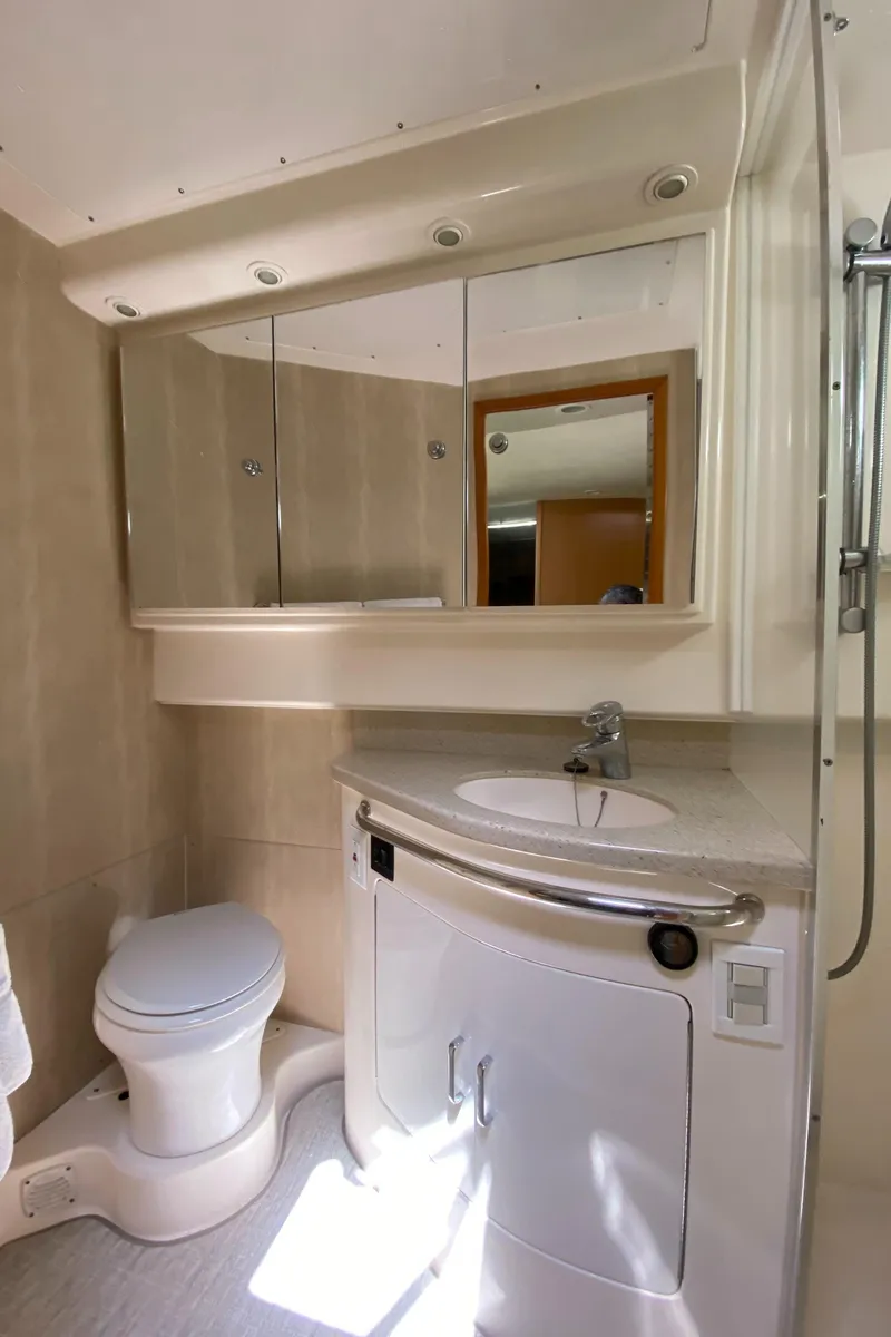 Slide: The Image of 2005 Cabo 40 Hardtop Express bathroom with modern fixtures and mirrored cabinet. - 32