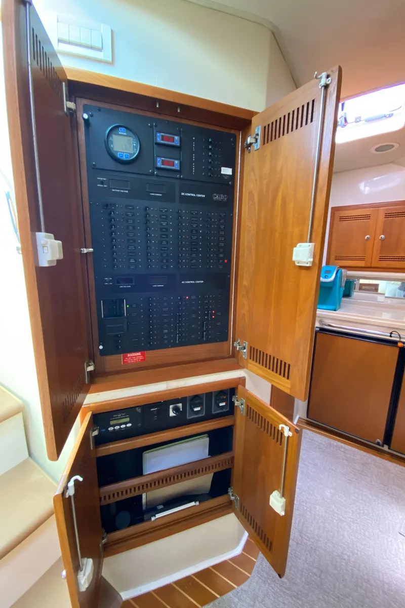 Slide: The Image of Electrical panel inside 2005 Cabo 40 Hardtop Express yacht, featuring wooden cabinetry. - 40