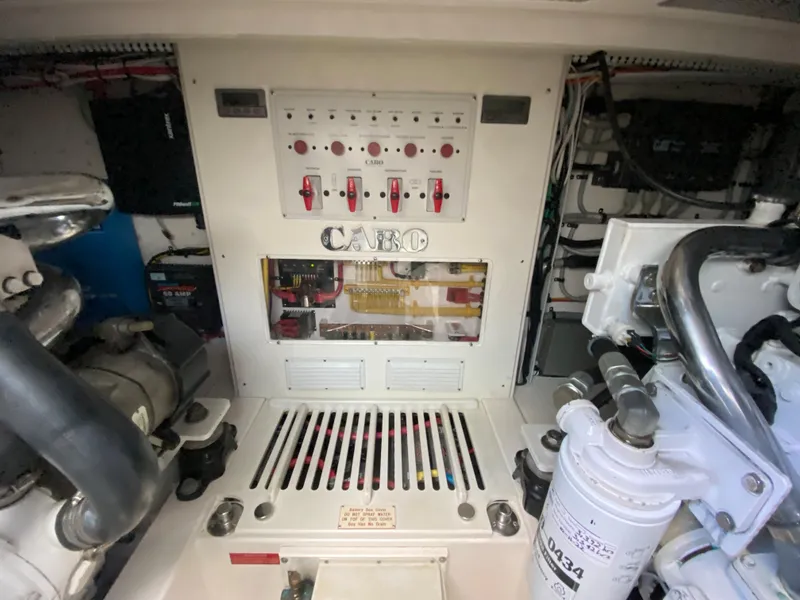 Slide: The Image of Engine room of 2005 Cabo 40 Hardtop Express with control panel and machinery. - 44