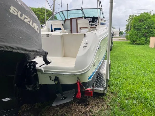 Slide: The Image of 1990 Sea Ray 240 Sundeck boat with Suzuki outboard motor on trailer. - 10