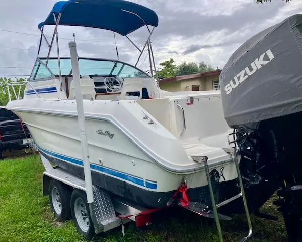 Slide: The Image of 1990 Sea Ray 240 Sundeck boat on trailer with Suzuki outboard motor. - 17