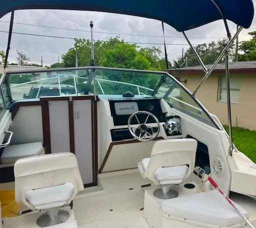 Slide: The Image of 1990 Sea Ray 240 Sundeck boat interior with helm, seats, and canopy. - 18