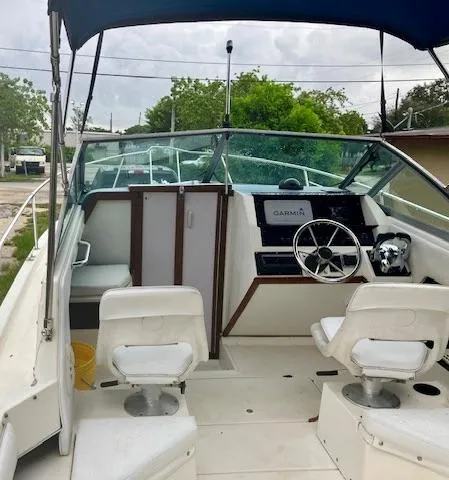 Slide: The Image of 1990 Sea Ray 240 Sundeck boat interior with steering wheel and seating. - 19
